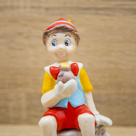 Pinocchio con Papera Seduto su un Tronco